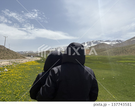 Hikers embracing landscape. Mountains chairs relaxation. mountains in spring silhouette of a tourist Hikers embracing landscape. Mountains chairs relaxation. mountains in spring silhouette of a tourist 137743581