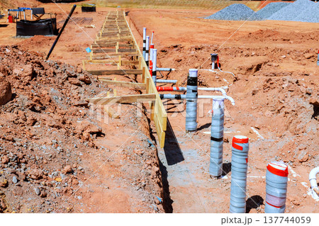 Construction site groundwork plumbing setup in new building area 137744059