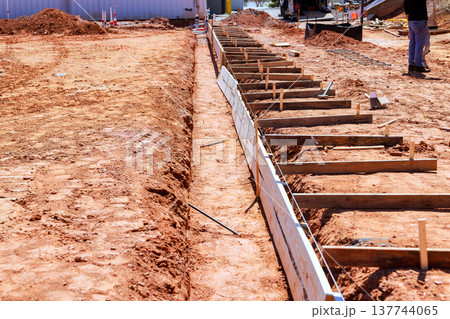 Construction site with wooden forms dirt for pouring concrete foundations Construction site with wooden forms dirt for pouring concrete foundations 137744065