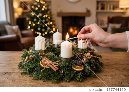 Lighting a candle on an advent wreath at christmas 137744120