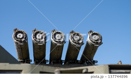 Launcher Pod Array Aligned Against Clear Blue Sky, Six Tubular Launchers In Parallel Cluster, Rugged Paint And Mounting Brackets Suggest Operational Readiness, Highcontrast Perspective Launcher Pod Array Aligned Against Clear Blue Sky, Six Tubular Launchers In Parallel Cluster, Rugged Paint And Mounting Brackets Suggest Operational Readiness, Highcontrast Perspective 137744896