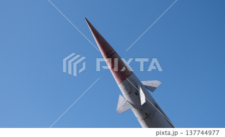 Rocket Nosecone Pointed Toward Sky, Sharp Red Tip Against Clear Blue Backdrop, Smooth Aerodynamic Panels And Rivets Visible, Telemetry Instrumentation Implied, Test Range Atmosphere 137744977