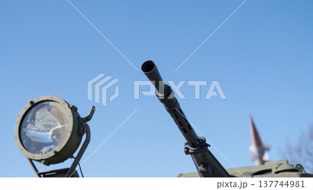 Spotlight And Gun Barrel Against Clear Sky, Closeup Of Armored Vehicle Exterior Showing Metal Texture, Rivets And Tactical Lighting, Calm Atmosphere With Precise Mechanical Detail Spotlight And Gun Barrel Against Clear Sky, Closeup Of Armored Vehicle Exterior Showing Metal Texture, Rivets And Tactical Lighting, Calm Atmosphere With Precise Mechanical Detail 137744981