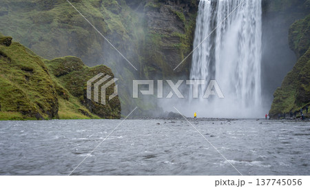 Wide shot of huge waterfall and river with people walking around, Iceland Wide shot of huge waterfall and river with people walking around, Iceland 137745056