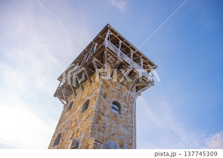 The lookout tower on Wysoki Kamien offers stunning views of the Jizera Mountains. Constructed from stone and wood, it stands tall against the sky, inviting visitors to explore its surroundings. The lookout tower on Wysoki Kamien offers stunning views of the Jizera Mountains. Constructed from stone and wood, it stands tall against the sky, inviting visitors to explore its surroundings. 137745309
