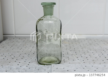 clear glass bottle with glass stopper on gray background. 137746254
