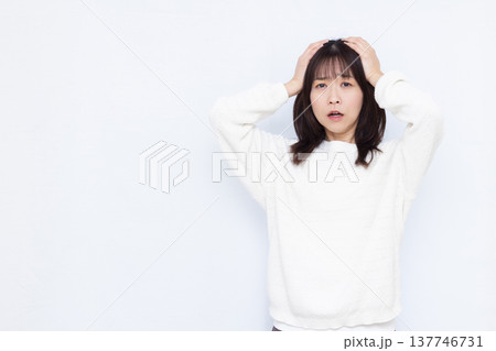 頭を抱えて驚く女性 頭を抱えて驚く女性 137746731