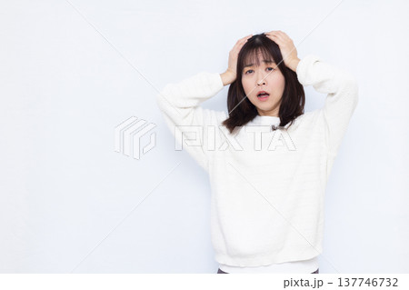 頭を抱えて驚く女性 頭を抱えて驚く女性 137746732