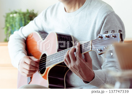 ギターを弾くミドル男性の手元 ギターを弾くミドル男性の手元 137747339