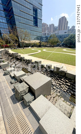 Modern architectural design with a water feature and manicured lawn in a city park Modern architectural design with a water feature and manicured lawn in a city park 137747441
