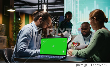 Corporate staff participate in late advisory board session with mockup, planning strategy and setting goals for project agenda. Experts reviewing updates with partners for success. Camera A. 137747469