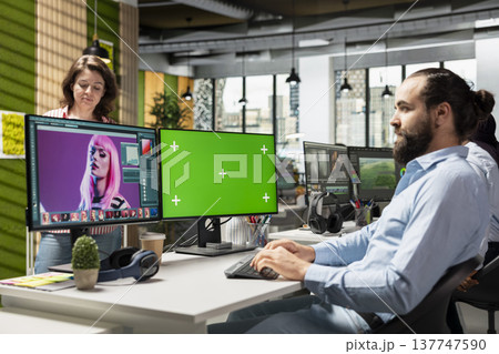 Green screen monitor next to editing software for commercial catalog photos, artistic design and color grading for advertising agency tasks in the office. Isolated mockup screen at desk. Green screen monitor next to editing software for commercial catalog photos, artistic design and color grading for advertising agency tasks in the office. Isolated mockup screen at desk. 137747590
