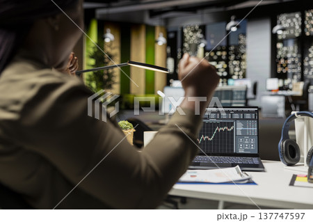 Joyful black analyst tracking global market trends and seeing indicators going up, feeling pleased and proud with the cryptocurrency success. Business development goals and economic growth. Joyful black analyst tracking global market trends and seeing indicators going up, feeling pleased and proud with the cryptocurrency success. Business development goals and economic growth. 137747597