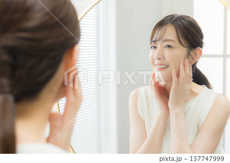 鏡を見てメイクする女性 　　 137747999