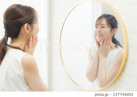 鏡を見てメイクする女性 　　 137748002