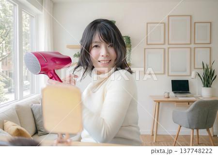 身だしなみを整える笑顔の女性 137748222