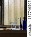窓際に置いてある歯ブラシとコップ 137749507