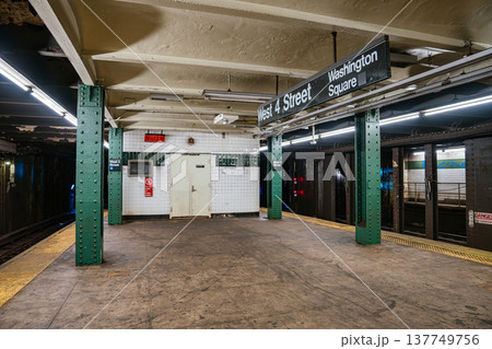 Empty New York City subway platform at West 4 Street Washington Square station in Manhattan. Underground metro station interior with green steel columns, tiled walls, and railway tracks. Empty New York City subway platform at West 4 Street Washington Square station in Manhattan. Underground metro station interior with green steel columns, tiled walls, and railway tracks. 137749756