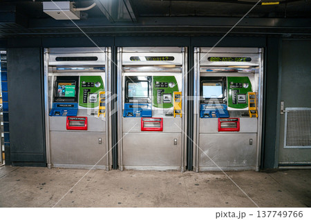 MetroCard vending machines line the wall inside a New York City subway station. The automated machines provide tickets and fare payment for public transportation. 137749766