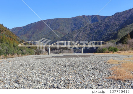和歌山・三重県境を掛ける瀞峡(北山川)の河原と瀞大橋(国道311号線) 和歌山・三重県境を掛ける瀞峡(北山川)の河原と瀞大橋(国道311号線) 137750413