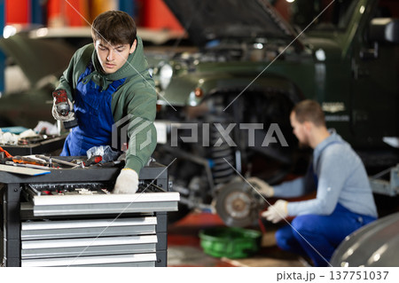 Portrait of car mechanic in overalls working in garage of car repair shop 137751037