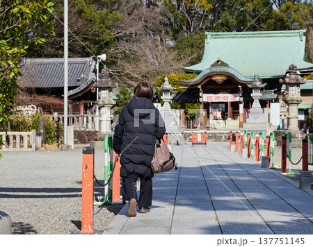 冬の昼の名古屋市の城山八幡宮に参拝する中年女性の姿 137751145