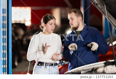 Woman Consulting Male Mechanic About Car Woman Consulting Male Mechanic About Car 137751203