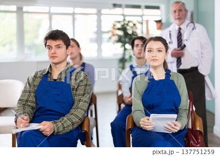 Young students in blue overalls listening to a lecture on medicine Young students in blue overalls listening to a lecture on medicine 137751259