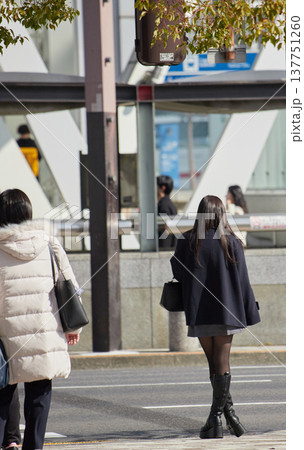 冬の昼の名古屋の繁華街の横断歩道で信号待ちの若い女性と人々の観光客の姿 冬の昼の名古屋の繁華街の横断歩道で信号待ちの若い女性と人々の観光客の姿 137751260