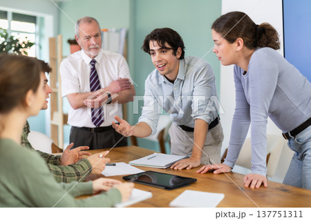 Students solving issues at the table in front of the teacher 137751311