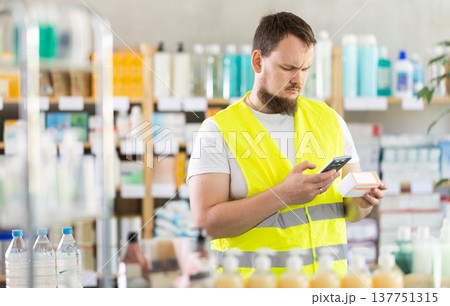 Young man builder scanning qr code of pills 137751315