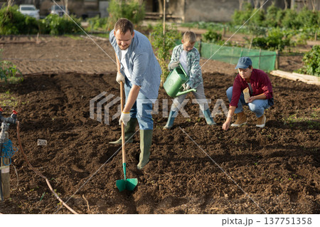Male farmer with shovel dripping garden Male farmer with shovel dripping garden 137751358