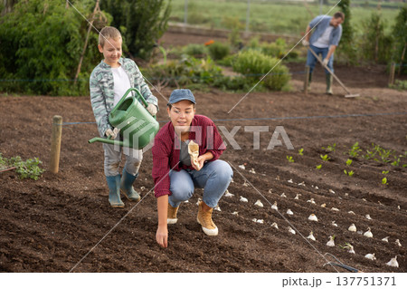 Woman and her son plant seeds Woman and her son plant seeds 137751371