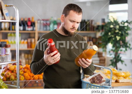 Grocery shopping - man chooses juice in supermarket 137751680