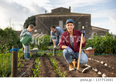 Young woman with hoe in harvest field 137751681