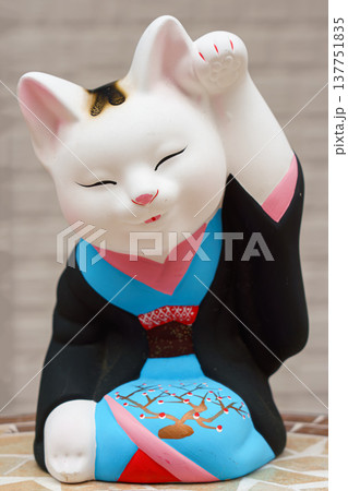 Tokyo, Japan - Sep 30 2024, vertical view of the sculpture of a seated smiling beckoning cat Maneki Neko dressed in a black and blue kimono, Tokyo, Japan Tokyo, Japan - Sep 30 2024, vertical view of the sculpture of a seated smiling beckoning cat Maneki Neko dressed in a black and blue kimono, Tokyo, Japan 137751835