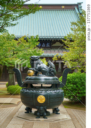 Tokyo, Japan - Sep 30 2024, vertical view of the bronze incense burner decorated with a lion statue, surrounded by trees, on road to Gotokuji Temple, without people, at daytime, Tokyo, Japan Tokyo, Japan - Sep 30 2024, vertical view of the bronze incense burner decorated with a lion statue, surrounded by trees, on road to Gotokuji Temple, without people, at daytime, Tokyo, Japan 137751869