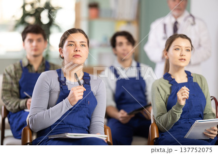 Young female student worker listening to lecture with medical professor in background 137752075