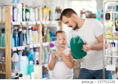 Young man and boy choosing detergent in store 137752126