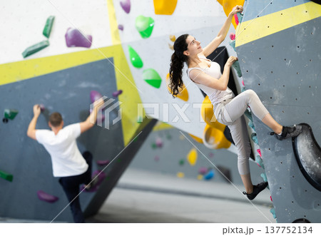 Young woman doing rock climbing on climbing wall 137752134