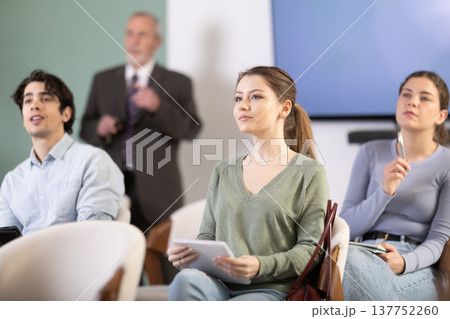 Young girl watching presentation with a teacher standing in background 137752260
