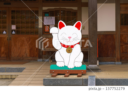 Tokyo, Japan - Sep 30 2024, Close-up view of the flat plywood figure of the beckoning white cat Maneki Neko, at the entrance to Gotokuji Temple, at daytime, without people, Tokyo, Japan Tokyo, Japan - Sep 30 2024, Close-up view of the flat plywood figure of the beckoning white cat Maneki Neko, at the entrance to Gotokuji Temple, at daytime, without people, Tokyo, Japan 137752279
