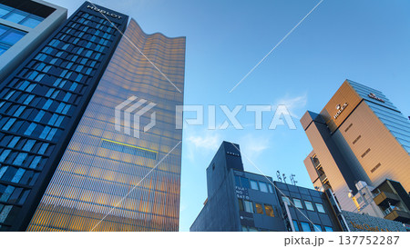Tokyo, Japan - Oct 14 2024,  A panoramic view from below of the glass facades of skyscrapers in the Ginza district, against the backdrop of a clear blue sky, in the evening, Tokyo, Japan 137752287