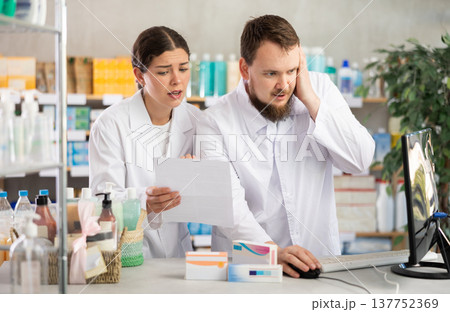 Two pharmacists annoyed near the computer Two pharmacists annoyed near the computer 137752369