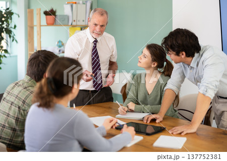 teacher talking to students near the table 137752381