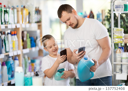 Dad and son scan barcode on packaging of laundry conditioner 137752408