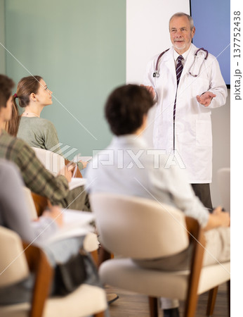Elderly male medical professor gives lecture to group of students 137752438