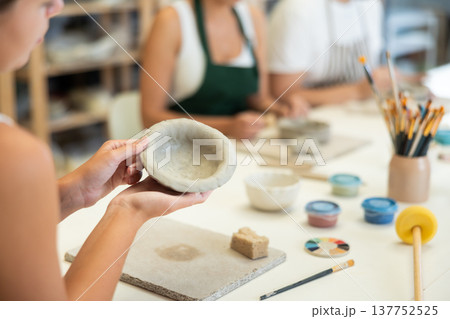 Close up girl forms bowl of clay during master class, top view 137752525