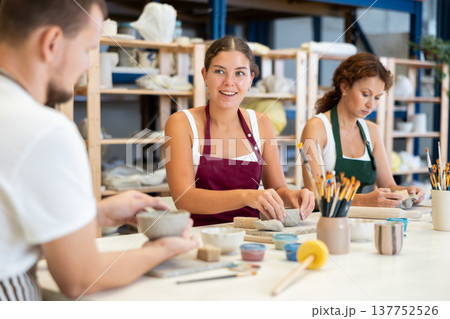 Three students in pottery workshop learn to create homemade plates and other utensils 137752526