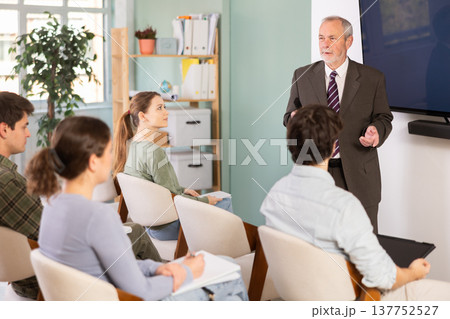 Elderly male teacher gives lecture to group of students 137752527